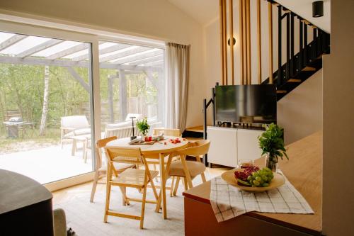 a kitchen and living room with a table and a television at Nomad Cabin Roztocze in Tereszpol Zaorenda