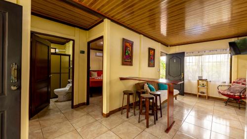 a living room with a bar and a bathroom at Hormiga's Houses La Fortuna in Fortuna