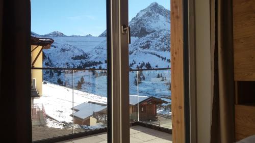 a window with a view of a snowy mountain at Modern ski-in Appartement 2020m Kühtai in Kühtai
