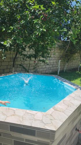 a swimming pool in front of a brick wall at Sheki Garden Guest House in Sheki