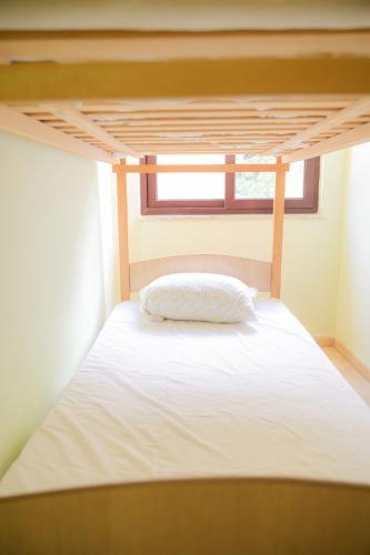 a bed in a room with a white bedsheet at Hotel Xhejsoni in Shëngjin