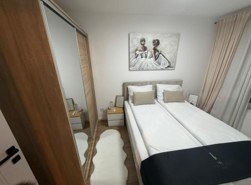 a bedroom with a bed and a painting on the wall at Apartman I&I in Kiseljak