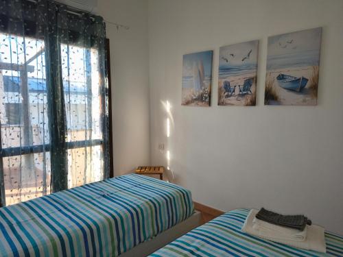 a bedroom with two beds and pictures on the wall at Seaside Home - Palau in Palau