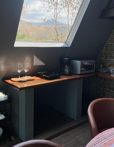 a table with two wine glasses and a window at Estancia las Jacarandas Cabañas in San Gabriel Etla
