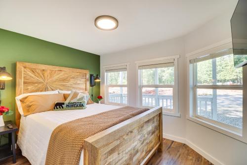 a bedroom with a large bed with green walls and windows at Gateway to Glacier! 2-Cabin Compound for Groups in Columbia Falls