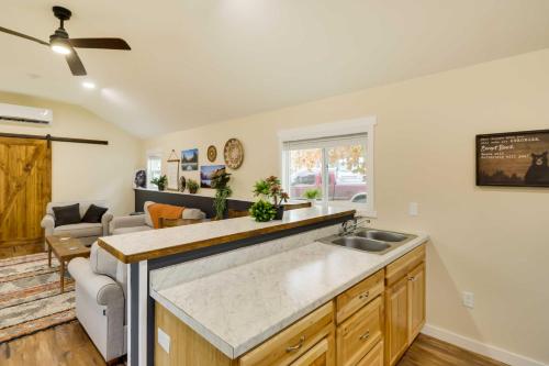 a kitchen with a sink and a living room at Gateway to Glacier! 2-Cabin Compound for Groups in Columbia Falls