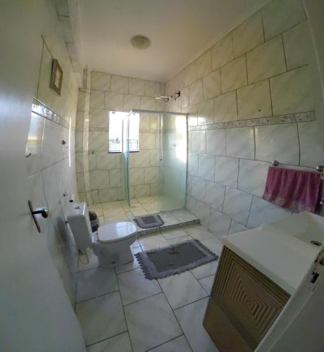 a bathroom with a shower and a toilet and a sink at Pousada Familiar 10 in Rio do Sul