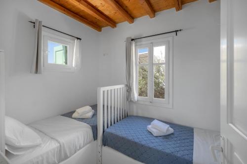 a bedroom with two beds and a window at Oneiro Serifos House in Serifos Chora