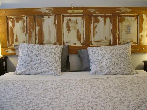 a bed with two pillows on top of it at Casa dos Pedro´s in Vila Nova