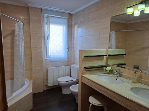 a bathroom with a sink and a toilet and a mirror at San Isidro in Villarcayo
