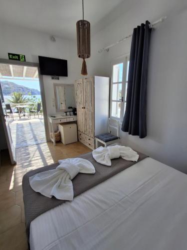 a bedroom with a bed with two towels on it at Sunset Hotel Kini Beachside in Kini