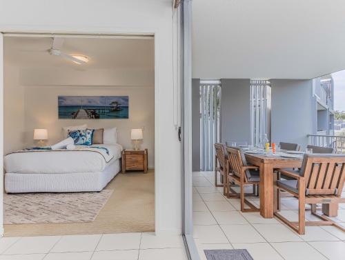 a bedroom with a bed and a dining room with a table at Drift North Beachfront Apartments - Private Apartments in Kingscliff