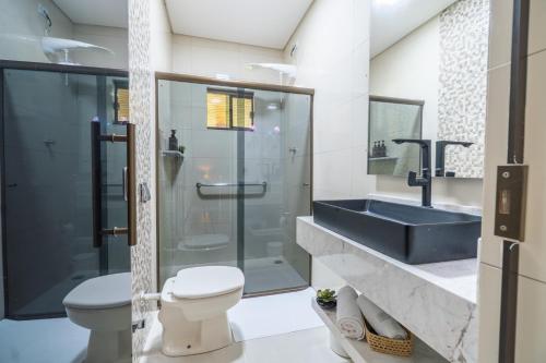 a bathroom with a sink and a toilet and a shower at Casa de Campo Mimosa Flor Refugio Exclusivo Proximo Cataratas e Aeroporto IGU Piscina Privativa 12 Hóspedes in Foz do Iguaçu