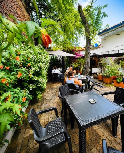 a patio with tables and chairs and people sitting at Granada Hostel in Bogotá