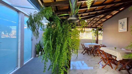 a room with a table and a bunch of plants at Pousada Canto das Samambaias in Capitólio