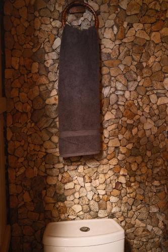 a stone bathroom with a towel hanging above a toilet at Casa Chuparrosas in San Mateo Río Hondo