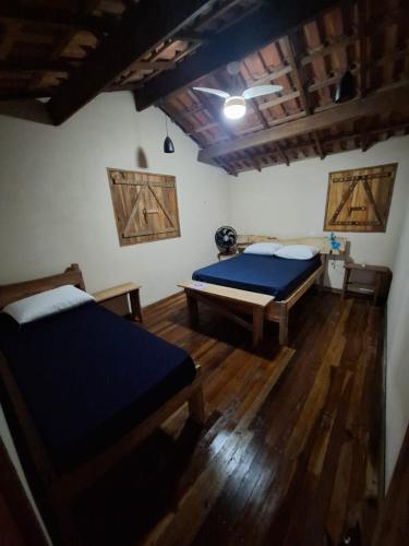 a bedroom with two beds and a wooden floor at Casa Petar Betari in Iporanga