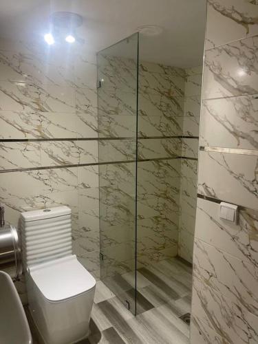 a bathroom with a toilet and a glass shower at Villa Moderne avec Piscine Privée in Imouzzer du Kandar