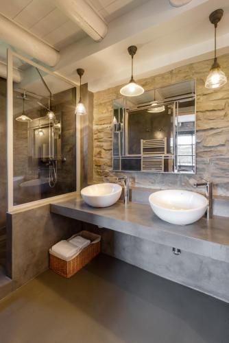 two sinks in a bathroom with two mirrors at Casas Pirineos in Sabiñánigo