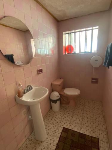 ein Badezimmer mit Waschbecken, Toilette und Spiegel in der Unterkunft Garra Charrua in Mérida
