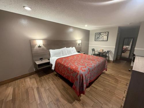 a hotel room with a bed with a red bedspread at SimpleStay Suites - Downtown San Bernardino in San Bernardino