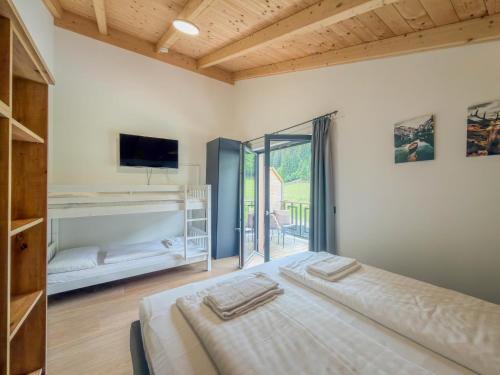 a bedroom with a bed and a tv and a window at Obermöschach 1A in Lake Pressegg