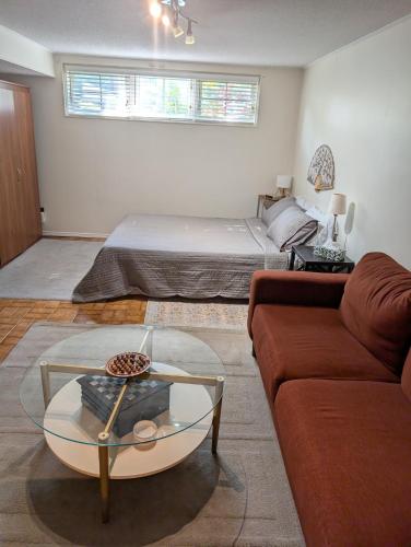 a living room with a bed and a couch at West End Basement Apartment in Toronto