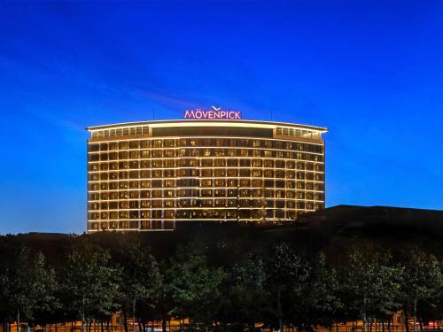 a large building with a sign on top of it at Mövenpick Hotel Istanbul Marmara Sea in Istanbul