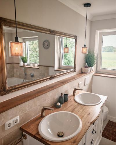 a bathroom with two sinks and a large mirror at Green Lake House in Petershagen