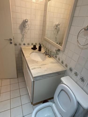 a bathroom with a sink and a toilet at Quatre Saisons Residence Apartamentos Duplex com linda vista em Campos do Jordão in Campos do Jordão