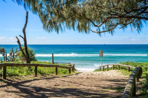 a path to the beach with the ocean in the background at Surfside Buddina Beachfront 3bed Apt - Direct Beach Access in Buddina
