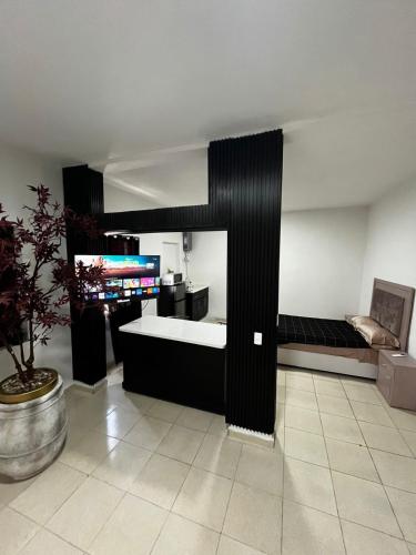 a room with a bed and a tv in it at Deluxe noir Loft cerca de parque fundidora in Monterrey