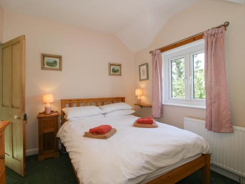 a bedroom with a bed with two pillows on it at Shepherd's Cottage in Bridgnorth