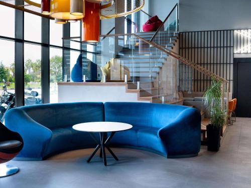 a blue couch in a room with a table at ibis Styles Batumi Hotel in Batumi