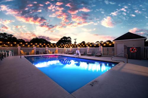 a swimming pool with a sunset in the background at The Windstar Hotel - Emerald Isle, Swansboro in Cedar Point
