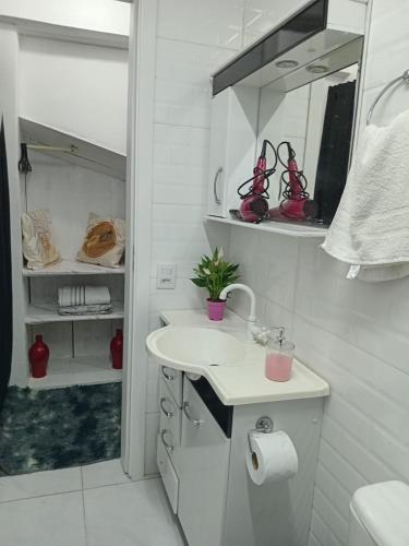 a white bathroom with a sink and a mirror at QUARTO AZUL com cozinha e piscina só sua in Capão da Canoa