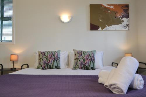 a bedroom with a bed with purple sheets and pillows at Spectacular Views, Convenient, Affordable - KK17129 in Kaikoura