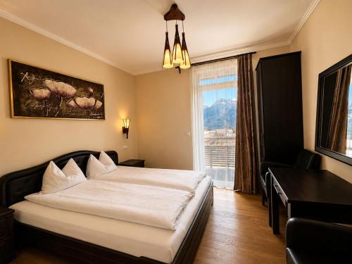 a bedroom with a large bed and a window at Transylvania Villa & Spa in Gosau