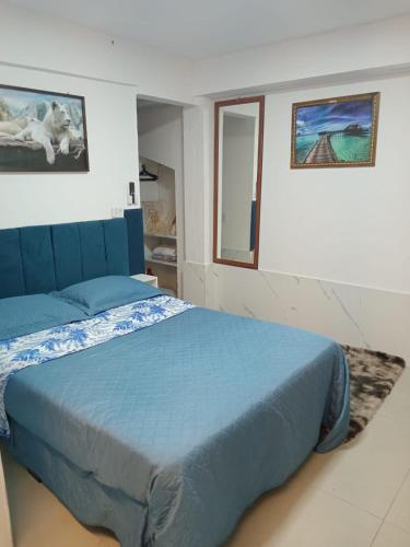 a bedroom with a blue bed and a window at QUARTO AZUL com cozinha e piscina só sua in Capão da Canoa