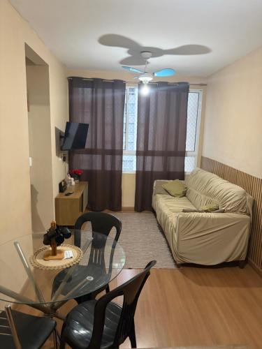 a living room with a couch and a glass table at Apto 2 qts em Xerém próximo ao CT do Fluminense in Duque de Caxias