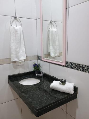 a bathroom with a sink and a mirror at Chalé Luar da Serra in Camanducaia