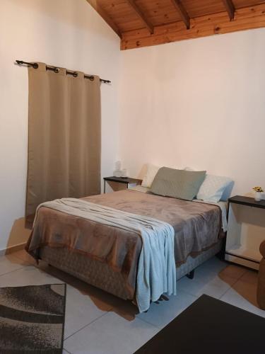 a bedroom with a large bed in a room at Chalé Luar da Serra in Camanducaia