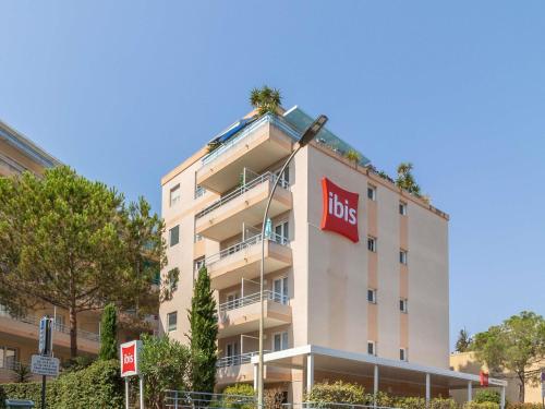 a building with a hos sign on the side of it at Ibis Roquebrune Cap Martin Menton in Menton