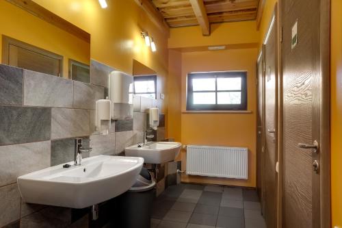 a bathroom with two sinks and yellow walls at Paegli Guest house in Kaijciems
