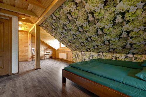 a bedroom with a wall with flowers on it at Paegli Guest house in Kaijciems