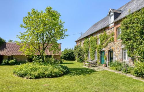 an old brick building with a bench in the yard at Maisons Falourdel in Soulles