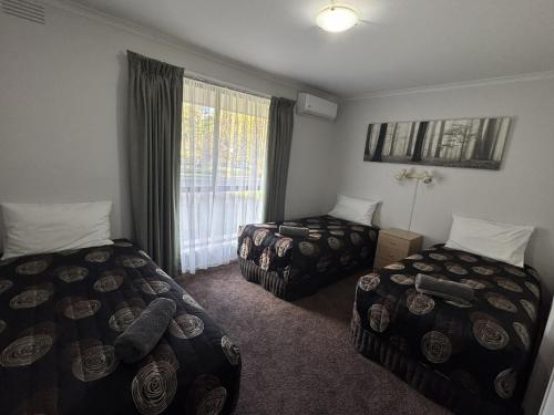 a hotel room with two beds and a window at Barwon Valley Lodge in Geelong