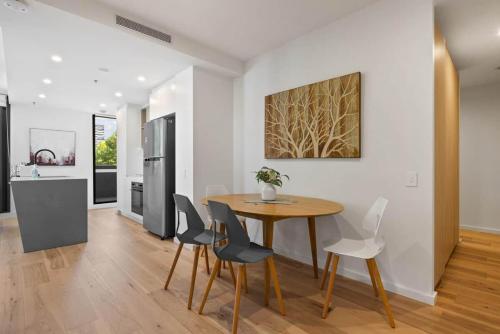 a kitchen and dining room with a wooden table and chairs at Central 2b2b with 2 Parkings across largest Mall in Braddon