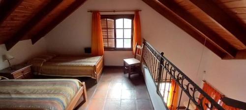 a attic room with two beds and a window at COMPLEJO LLATANI in Los Reartes