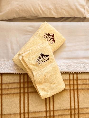 a pair of towels sitting on top of a bed at Ayllu in Huaraz